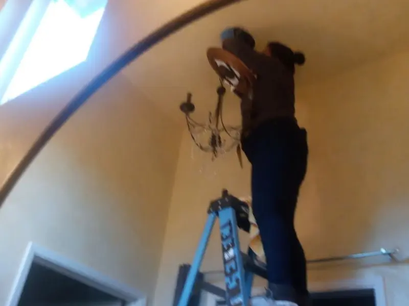 Electrician installing a chandelier in a Gardena residence